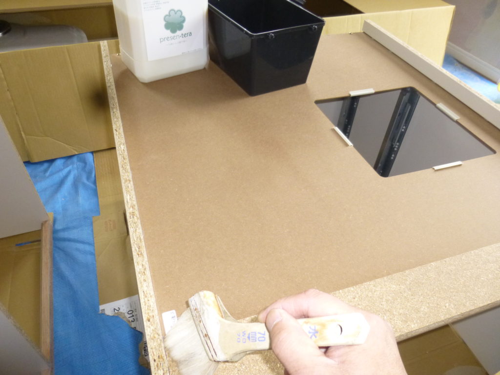 システムキッチン裏面にリバースワックスを塗っている様子